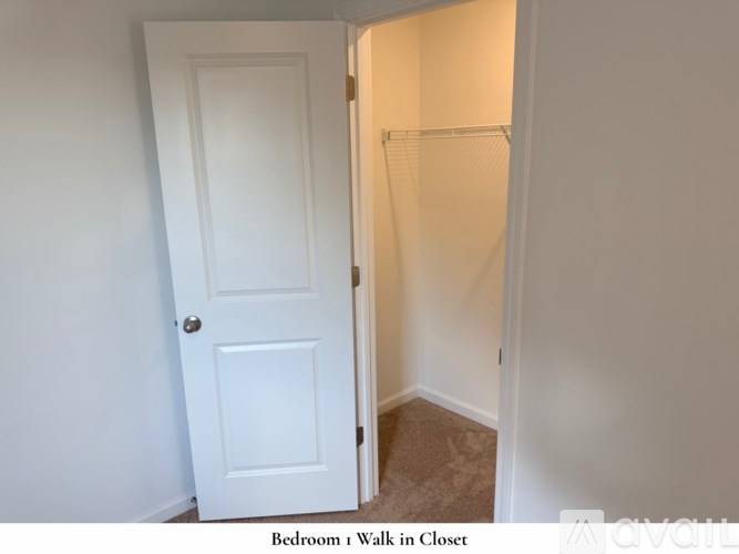 A room with a carpeted floor and a window showing a view of a house.