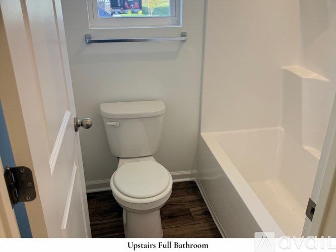 A room with a carpeted floor and a window letting in sunlight.