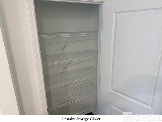 A white door is open to a hallway with a carpeted floor.