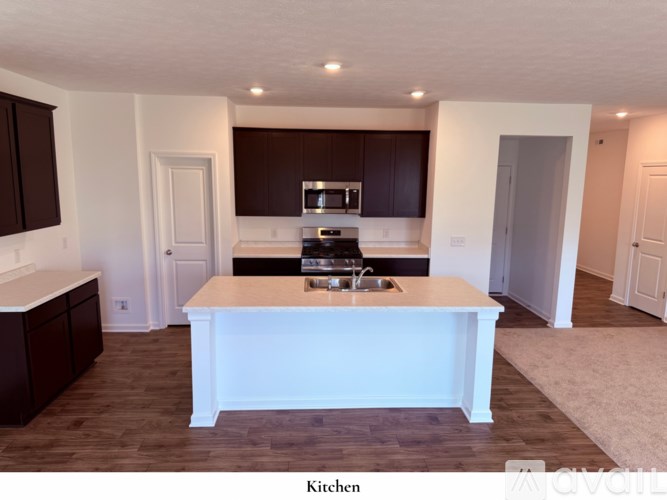 A kitchen with a white island and brown cabinets.