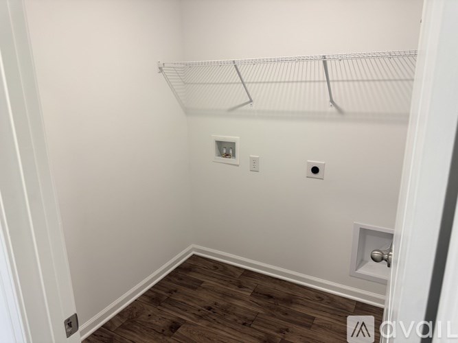 A white closet with a shelf and a door.