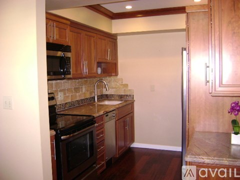 A kitchen with wooden cabinets and a black stove top oven.