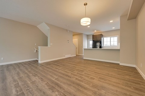 A spacious room with wooden flooring and a large window.