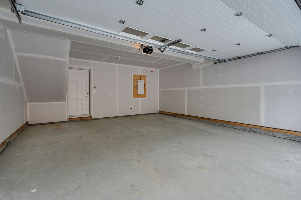 A room with a white ceiling and a door on the left side.