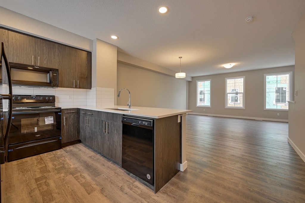 A modern kitchen with dark wood cabinets and stainless steel appliances.