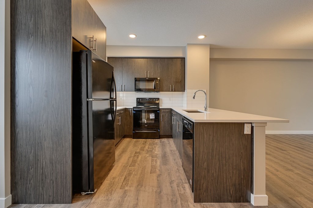 A modern kitchen with dark wood cabinets and a white countertop.