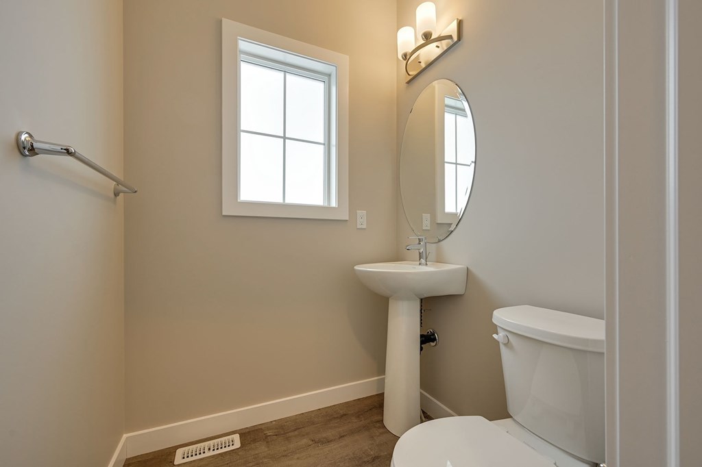 A white toilet sits next to a sink in a bathroom.