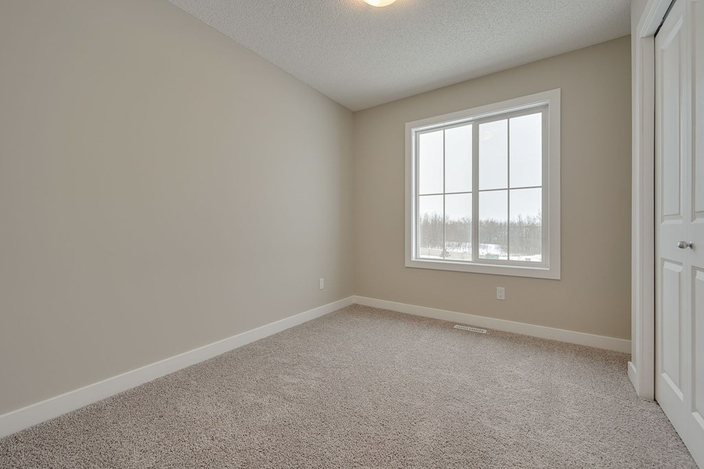 A room with a carpeted floor and a window.