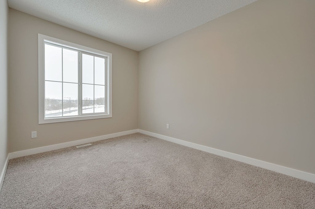 A room with a carpeted floor and a window.