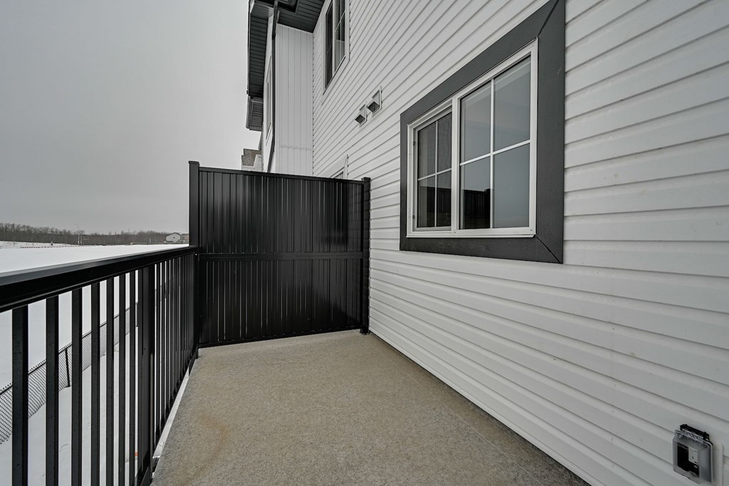 A white house with a black gate and a window.