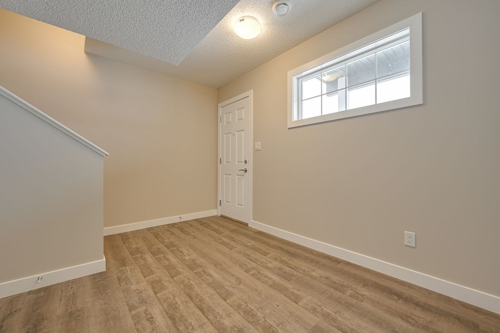 A room with a white door and a window with a white frame.