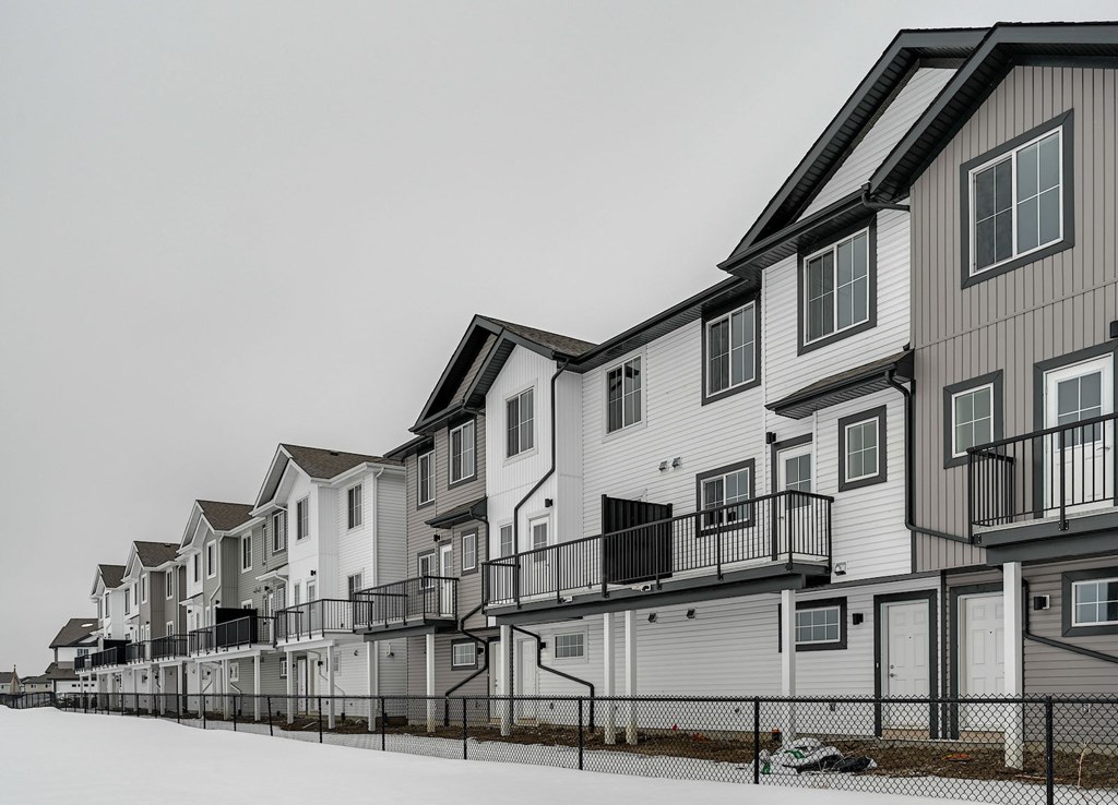 A row of houses with balconies and garages.