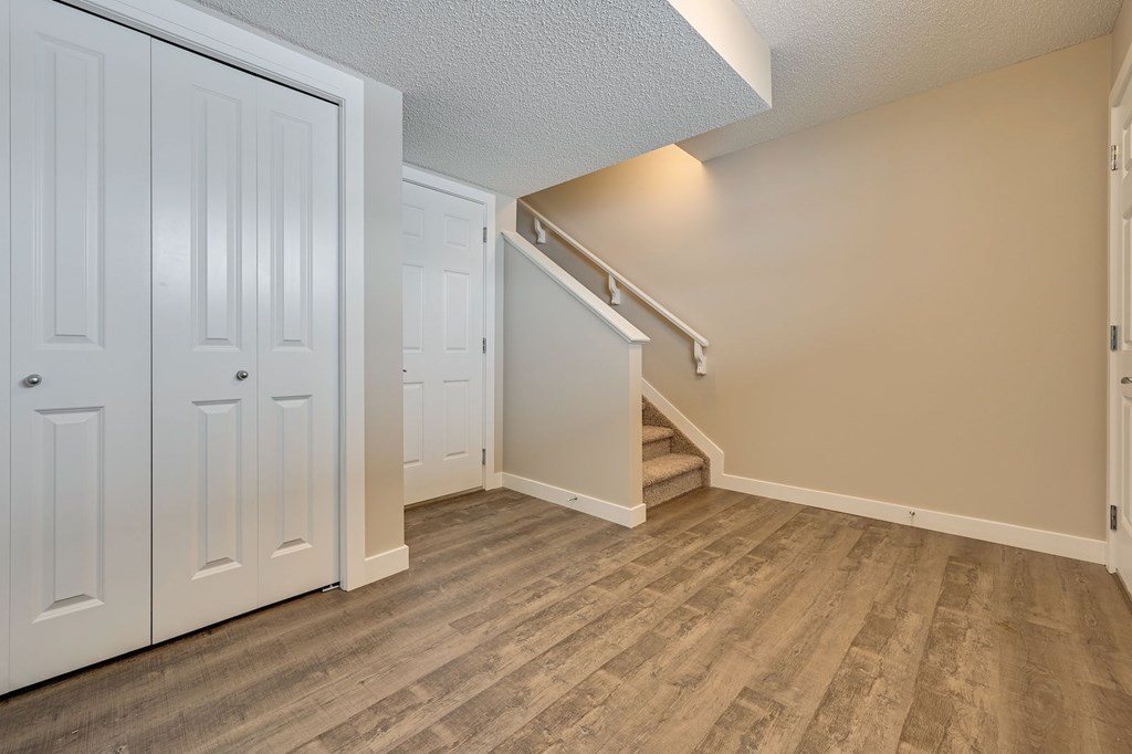 A room with a staircase and white doors.