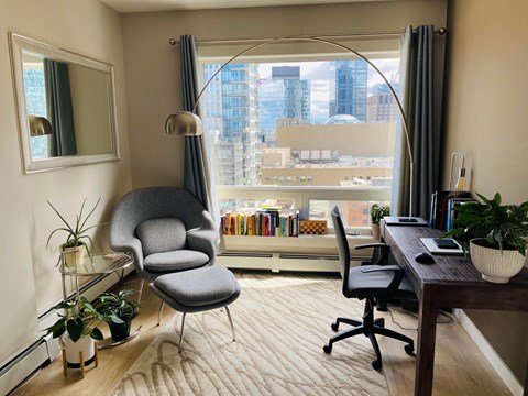 A modern home office with a large window overlooking the city.