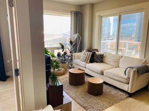 A living room with a white couch and a large window.