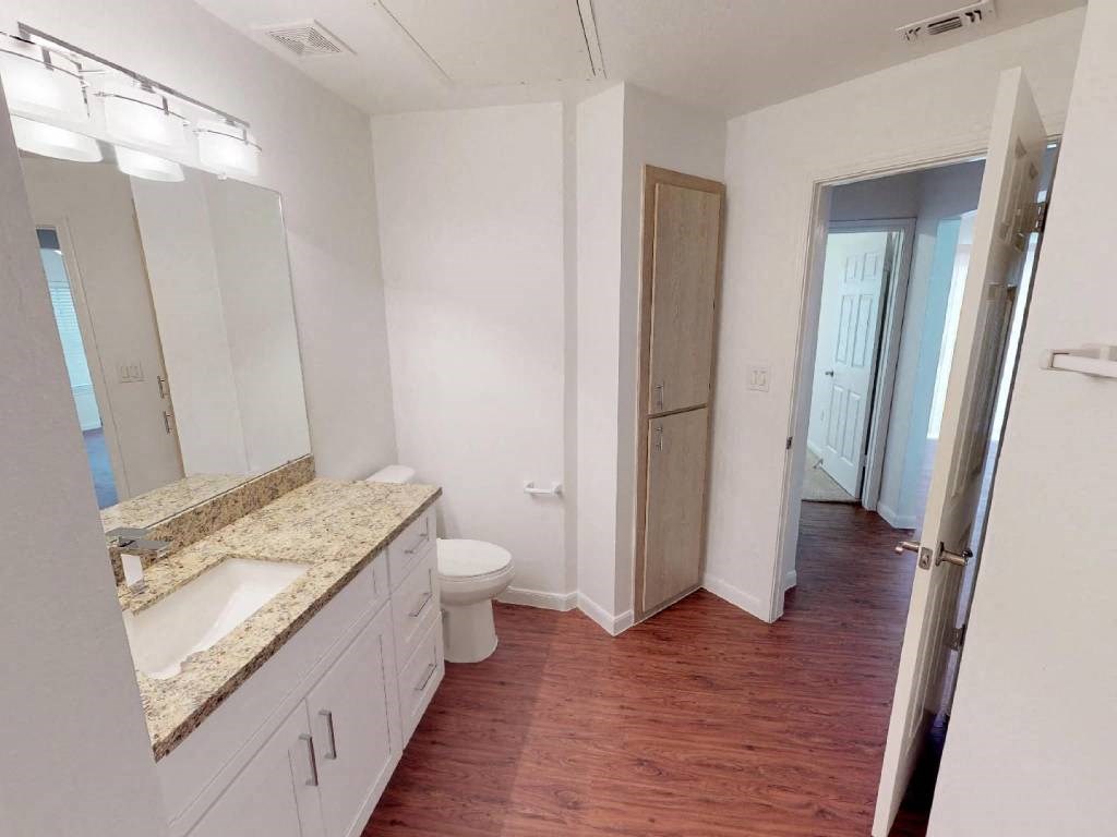 A bathroom with a sink, toilet, and mirror.