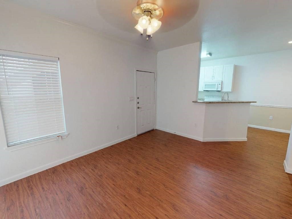 A room with wooden floors and a white ceiling with a light fixture.