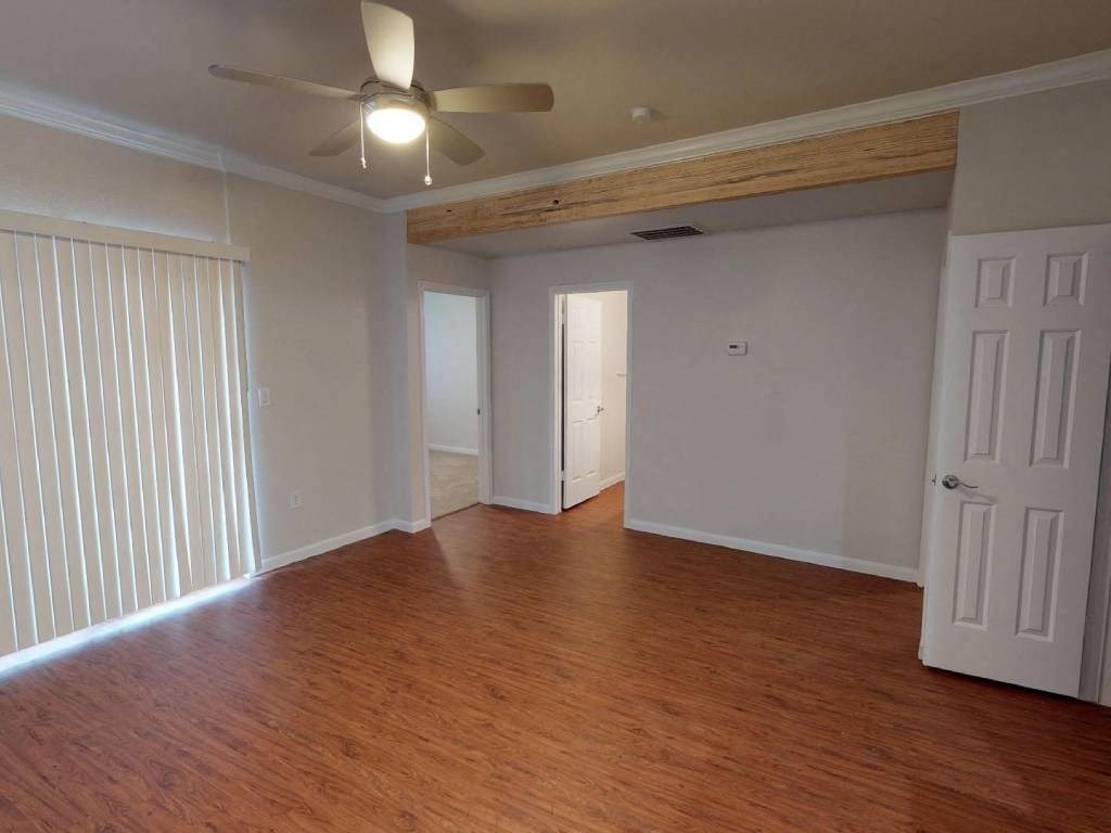 A room with wooden floors and a ceiling fan.