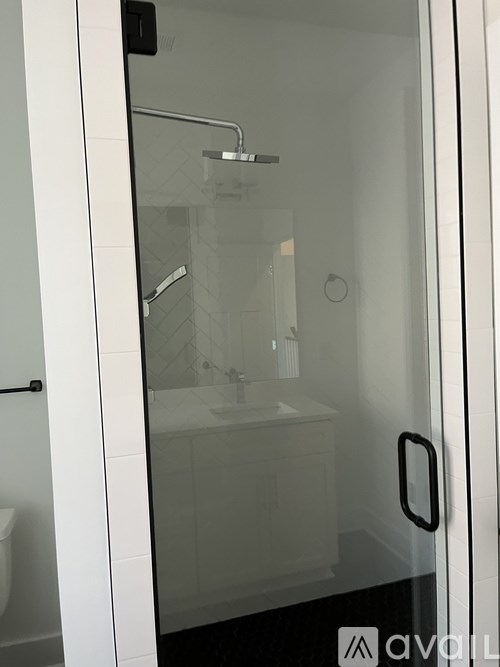 A white bathroom with a glass shower door.
