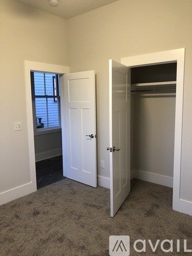 A room with a white door and a window with blinds.