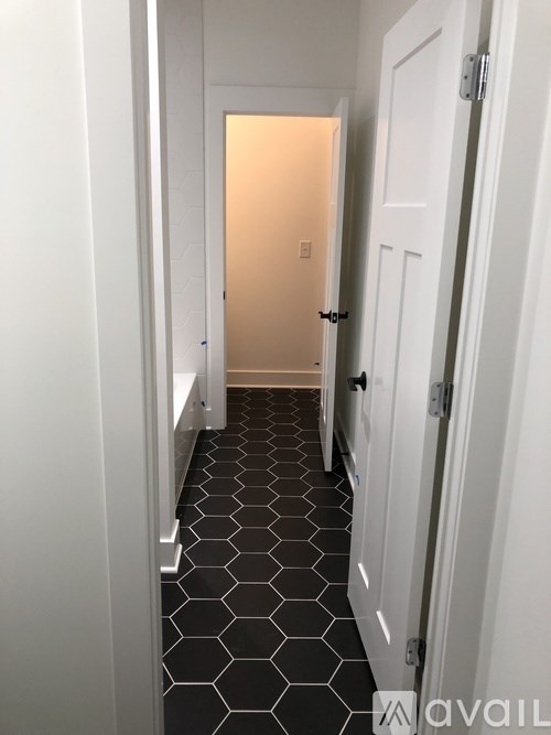 A hallway with a black and white tiled floor.