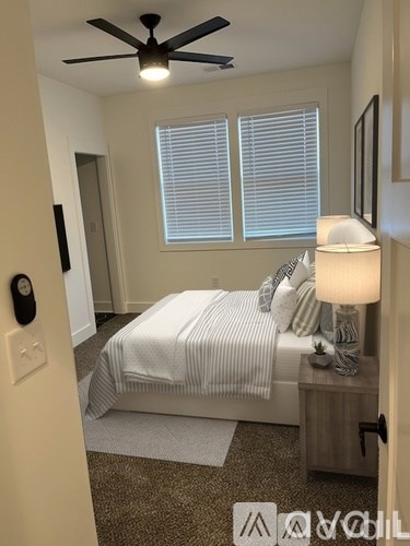 A bedroom with a bed, nightstand, and ceiling fan.