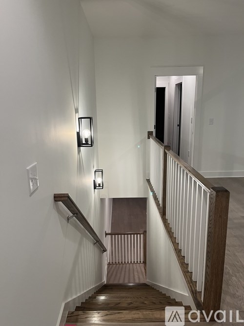 A staircase with a light on the wall.