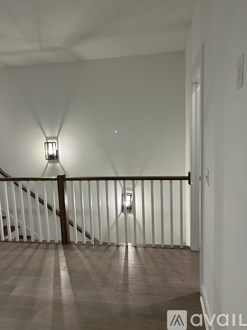 A staircase with a light on the side and a wall socket on the wall.