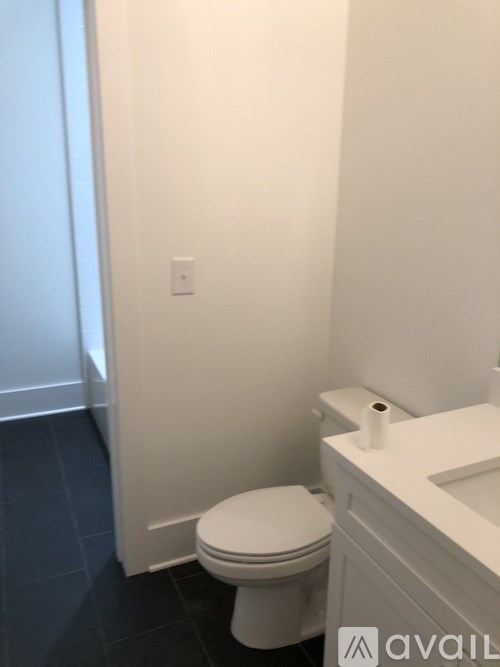 A white toilet in a bathroom with a white sink.