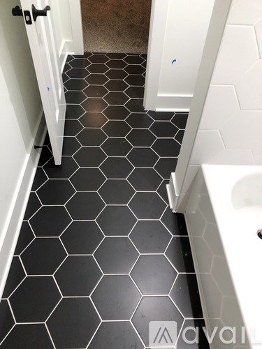 A bathroom with a black hexagonal tile floor.