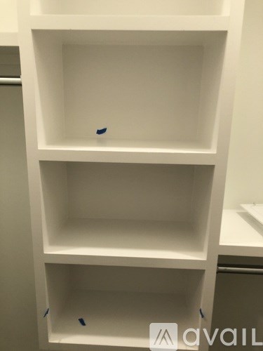 A white shelf with three compartments is empty.