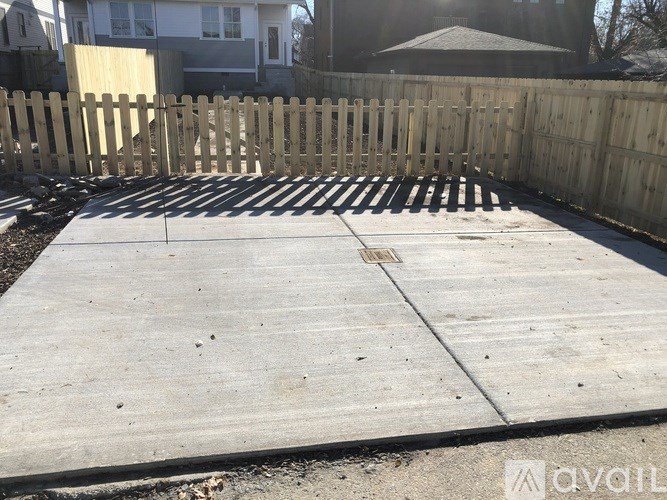 A concrete patio with a wooden fence in the background.