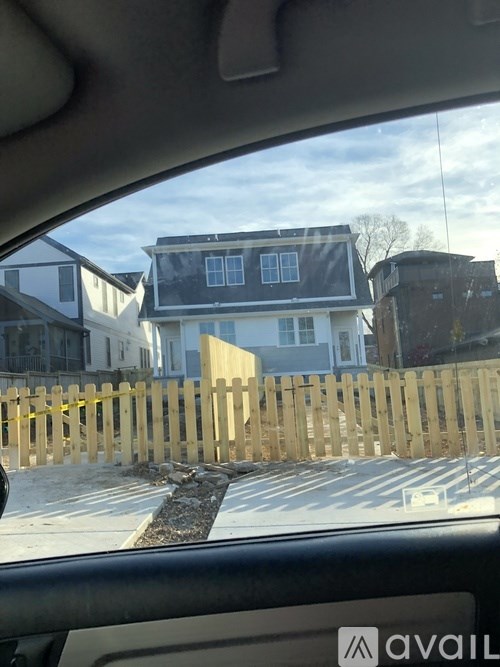 A car's interior with a view of a house under construction through the windshield.