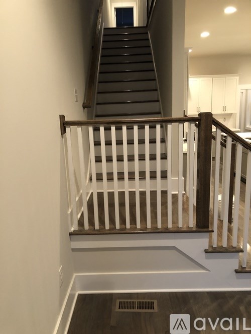 A staircase with a wooden handrail and white balusters.