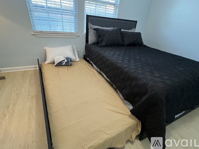 A bedroom with a bed, pillows, and a window.