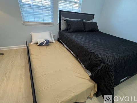 A bedroom with a bed, pillows, and a window.