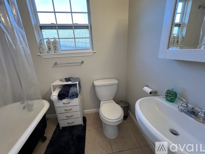 A bathroom with a toilet, sink, and bathtub.