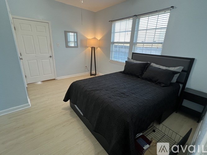 A bedroom with a bed, a lamp, and a window.