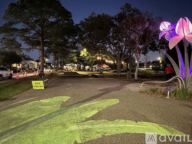 A park with a bike parking area and a purple flower light.