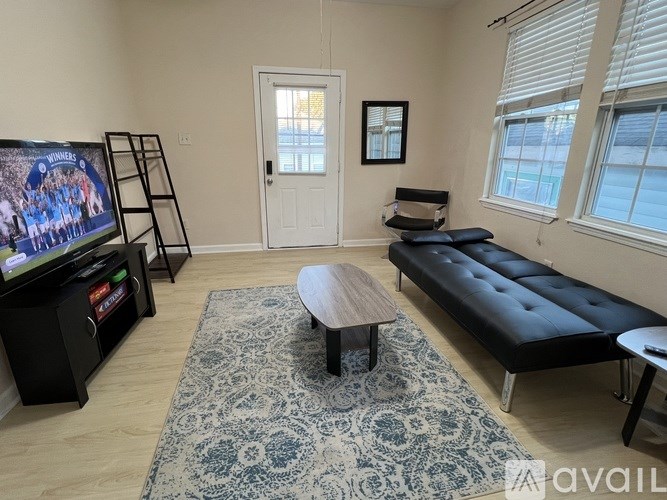 A living room with a television, a sofa, and a coffee table.