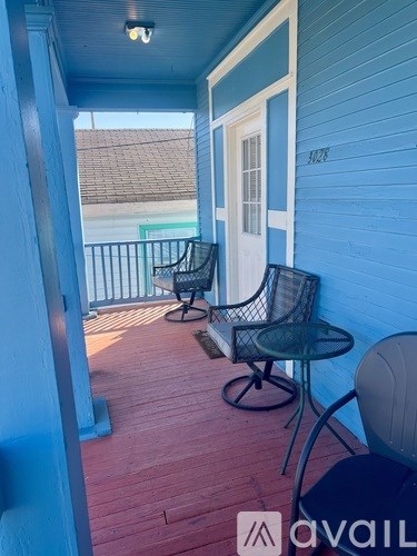 A patio with a table and chairs on a wooden deck.