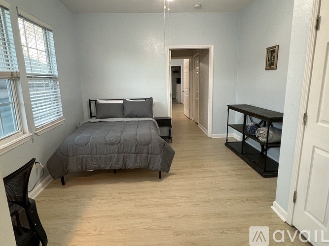 A bedroom with a bed, desk, and chair.