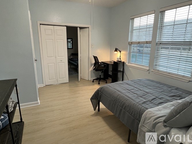 A bedroom with a bed, desk, and chair.