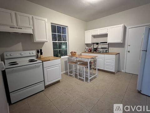 A kitchen with white appliances and cabinets.