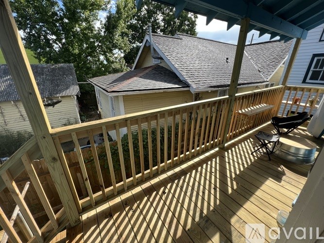 A wooden deck with a blue roof and a chair.