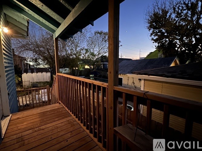 A wooden deck with a bench and a table with a lit candle on it.