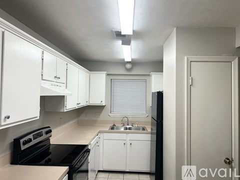 A kitchen with white cabinets and a black stove top oven.