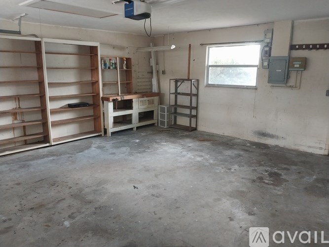 A room with a lot of shelves and a table in it.