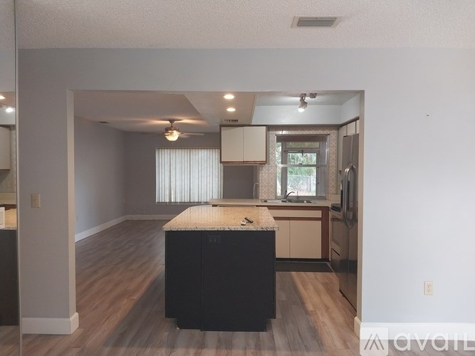 A kitchen with a black island in the middle of the room.