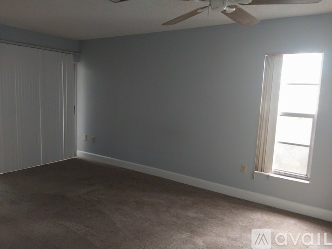 A room with a ceiling fan and a window.